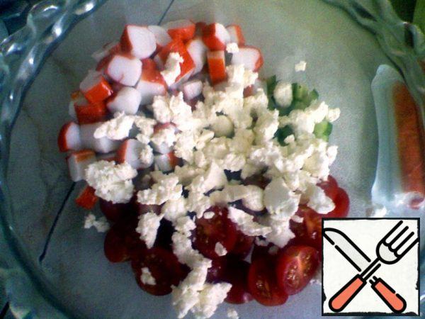 Cut crab sticks into rings.
Cut the cucumber into small cubes.
Cut the tomatoes in half.
Lettuce to break it up.
Roll the cheese into small balls.