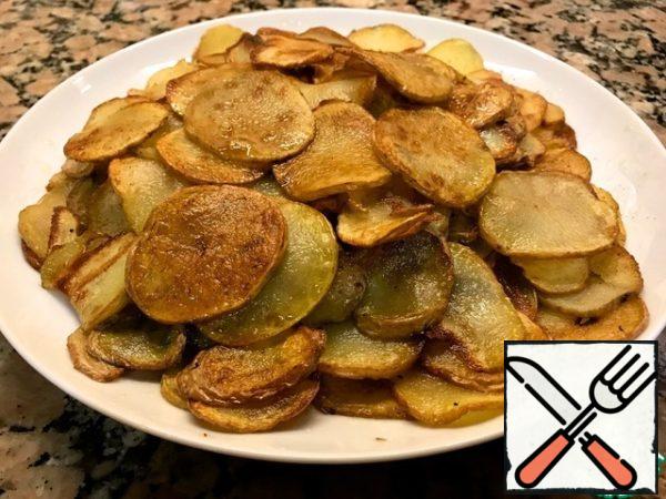 Cut the potatoes into thin slices and fry in olive oil until golden brown.

