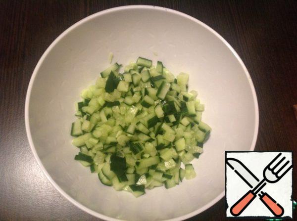 Prepare the vegetable filling. Cut the cucumber into small cubes.