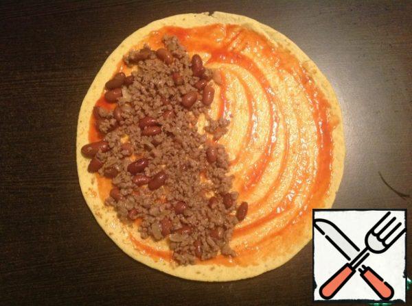 Evenly distribute 1/6 of the minced meat over one half of the tortilla.
