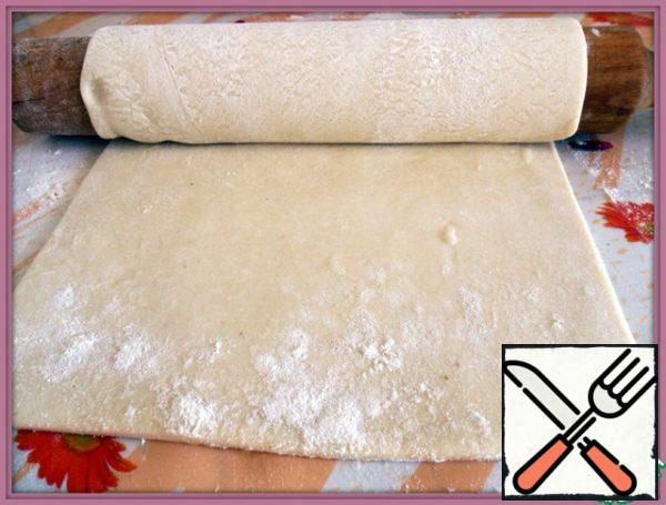 Well sprinkle the table and rolling pin with flour and roll out our dough in a rectangular layer thickness of 1 mm. since the package 2 of test records, I decided to make one immediately, and the second, as usual, freeze.