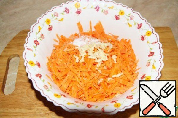 Add to the carrots 2 tbsp. of salt without slides and the garlic (through the frog).
Carrots lightly mash, allow to stand.