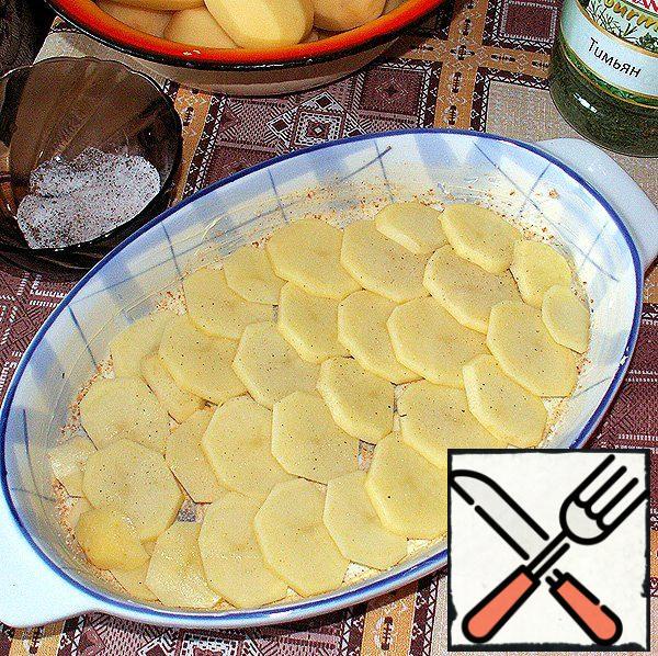 Cover the bottom of the mold with a layer of potatoes, which sprinkle with a mixture of salt and spices.
