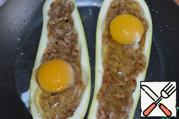 Add salt to the squash boats, half fill with stuffing. Pour the broth into the pan, put the stuffed zucchini, carefully break one egg into each half, add salt. Cover and put on the fire.
Cook for about 10 minutes, the protein should be ready, and it is better to leave the yolk liquid.
