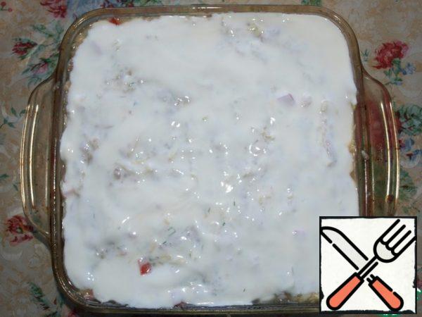 Grease the mold with vegetable oil, lay out our casserole. Grease the top with sour cream.
