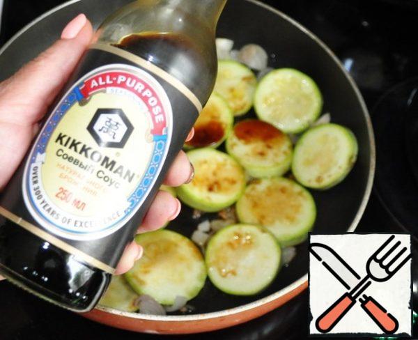 Pour the zucchini with onion and soy sauce.
