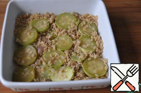 Take a baking dish, put it in zucchini with rice so that most of the zucchini was on top. The mixture should remain a little liquid, the rice was not dry. If there is no liquid, add some broth.
