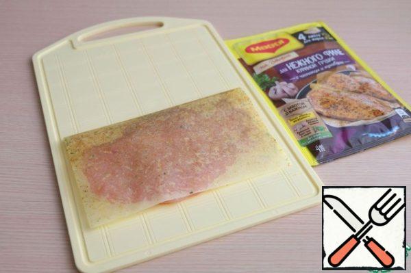 Cover with the second half of the sheet. Press the wrapped breast with your hand.
Place the wrapped breast on a preheated frying pan without oil. Fry on both sides.