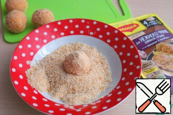 Roll the potato ball in breadcrumbs.

