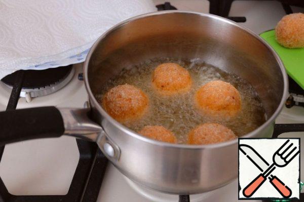 Add vegetable oil to the container. I want to note that the amount of oil for deep-frying depends on the capacity of the dishes. Heat the container with oil, then place the potato balls. Deep-fry the potato balls.