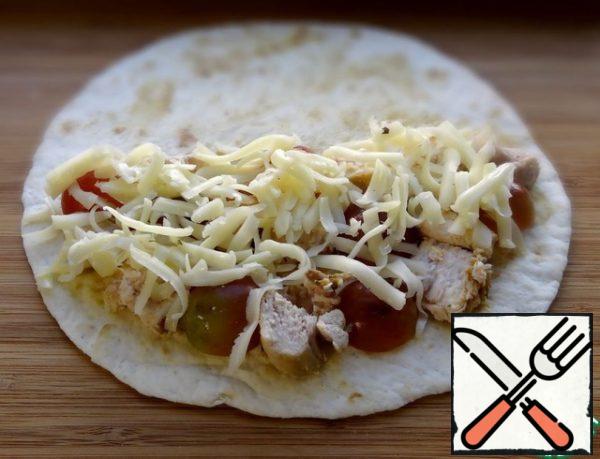 Use a cooking brush to apply a thin layer of mustard to the tortilla. Put a third of the fillets, grapes and cheese on one half of the tortillas.
