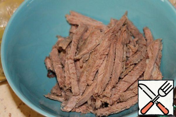 Cut beef into strips.
