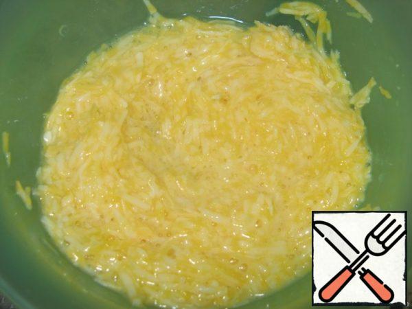 Grate the cheese. Set aside 2 tablespoons of cheese and mix the remaining one with the egg.