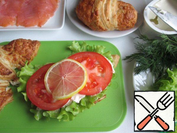 Cut the croissants in half lengthwise. Put lettuce leaves on the lower halves and generously smear with cream cheese (or other, to taste). Then put the tomato slices and lemon slice.

