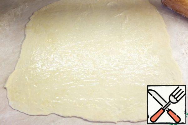 The dough is spread on the work surface, lightly dusted with flour. Rolling pin roll out the dough as thin as possible. The dough is elastic, pliable, does not tear.
Egg lightly whisk.
Lubricate the surface with beaten egg.