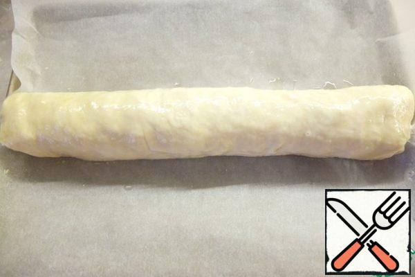 Wrap in a tight roll. Spread on a baking sheet covered with baking paper. Grease liberally with egg.