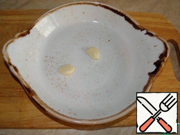 Cut the garlic into slices, cut in half and put it in a baking dish. (it is better to use a ceramic or cast iron mold)

