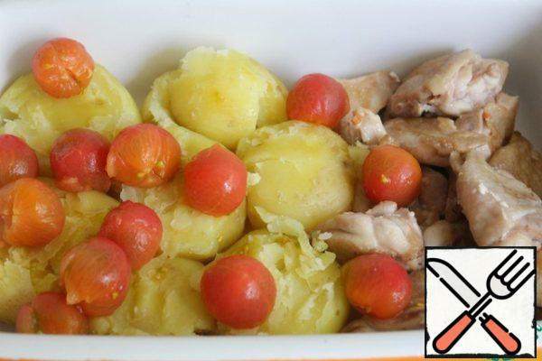 Peel the tomatoes, spread the potatoes and tomatoes over the thighs.
