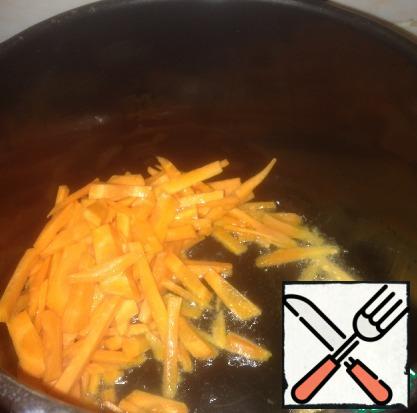 On the heated vegetable oil fry the carrots, then add the beef.