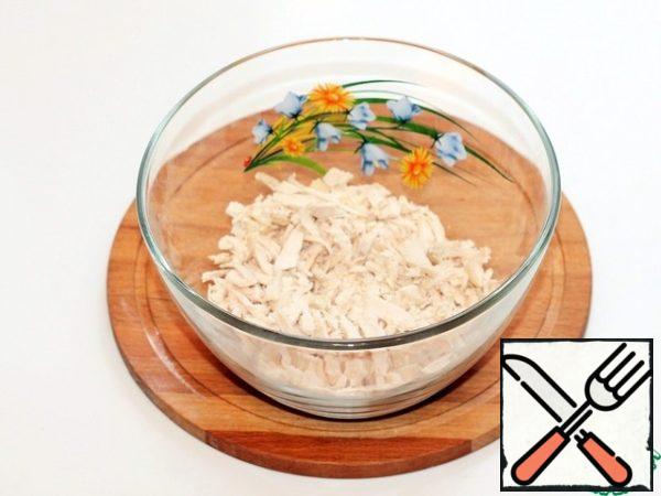 Finely chop the boiled chicken fillet and put it in a large bowl.
