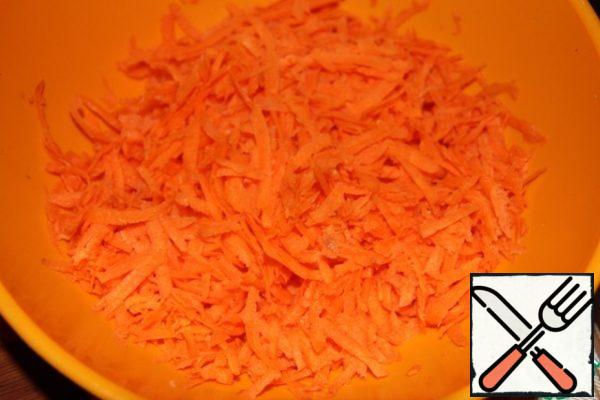 Grate the carrots in a bowl on a large grater.