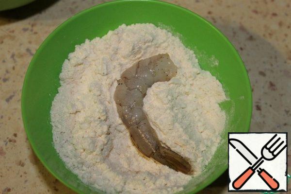 For breading, you will need 3 containers for flour, eggs and crackers. Add a little salt to each dough. Roll the first shrimp in flour on both sides.
