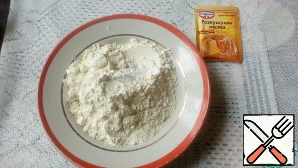 Then add the flour with baking powder and stir well. The dough is quite thick. Spread half of the dough in shape, smooth.