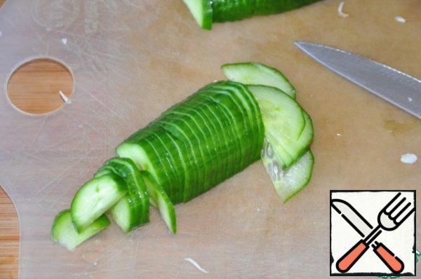 Thin half-rings cut cucumber.