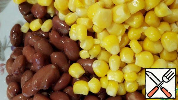 Pour the beans and corn into a bowl, add the cucumber and crushed garlic clove to them.