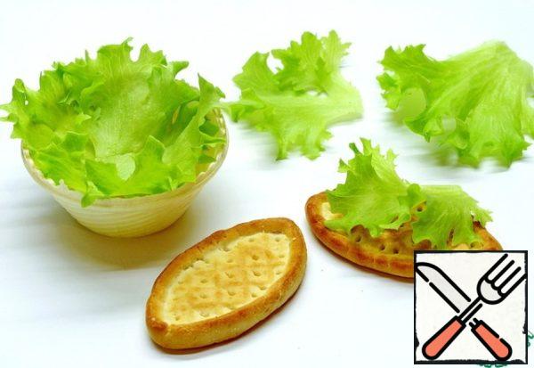 To tartlets or crackers are not quickly soaked under the influence of the sauce, lettuce leaves should be placed on the tartlets. They will serve as an ornament and at the same time protect from getting wet.
