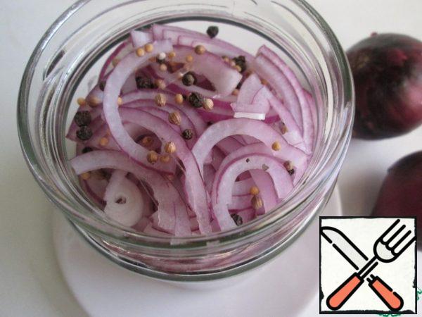 In a clean, dry jar, lay out half-rings of red onion in layers, sprinkling each layer with a mixture of spices. Fill the jar completely.
