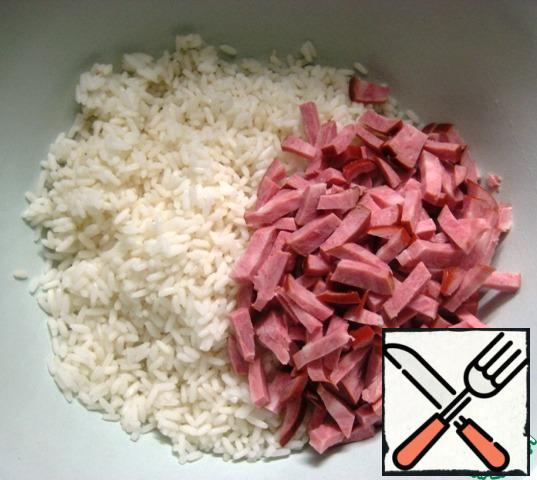 In a bowl, combine the pre-boiled and cooled rice, cut into small pieces of ham.