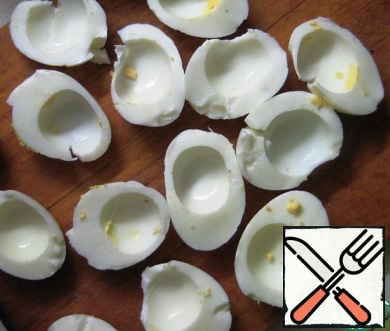 Boil hard boiled eggs, cool, clean, cut into two parts, remove the yolks.