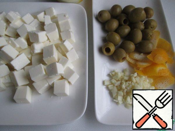 Cut the feta into cubes.
With a vegetable peeler, cut the zest from the lemon.
Cut garlic into cubes or plates.
Remove the olives from the jar and let the liquid drain.