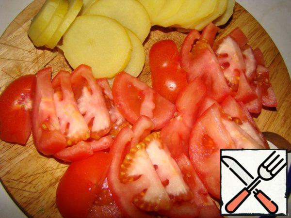 Boil the potatoes...cool...cut into circles..Cut tomatoes into slices