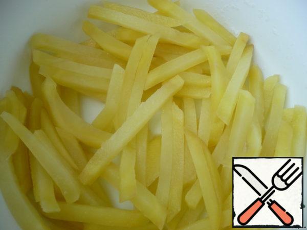 Cut the potatoes on a grater for French fries. If there are no floats, just cubes. Put in a saucepan, pour boiling water, salt. Allow to stand for 15 minutes, the water is drained.