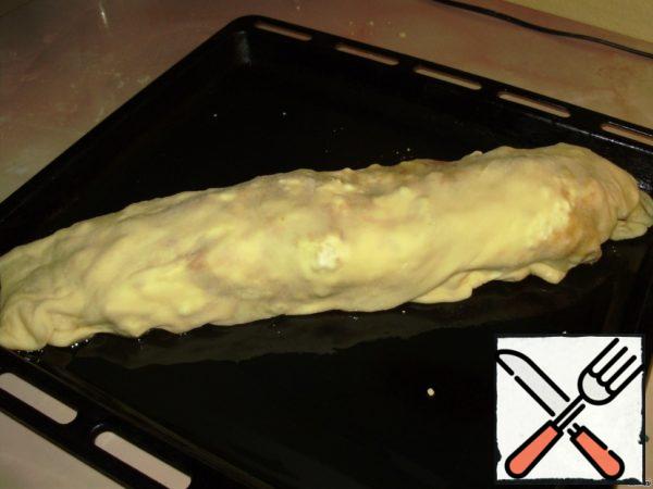 Grease a baking sheet with butter, lay out the strudel, brush with butter on top. Bake for 30 minutes at a temperature of 220 C.
