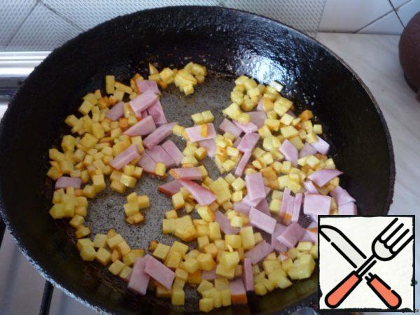 Add the sliced ham to the pan with the potatoes.
