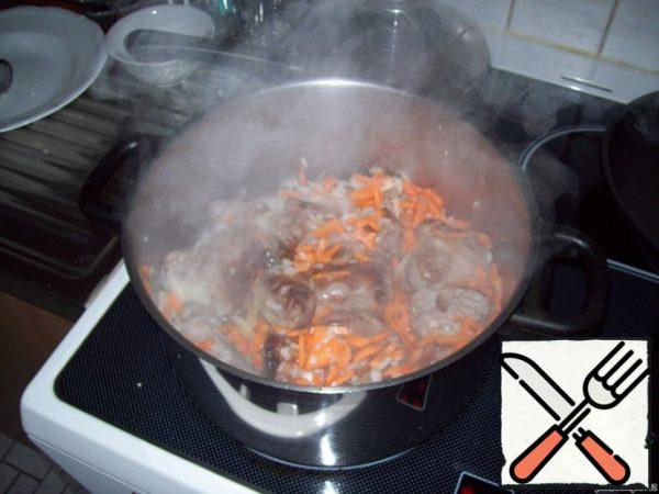 To the fried meat, add medium-sliced onions and carrots (can be semi-rings), cut into strips or grated on a coarse grater, fry everything a little.
