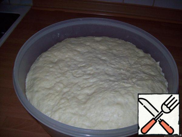 And here is and dough is prepared. Spread the dough from the Cup on the floured work surface of the table