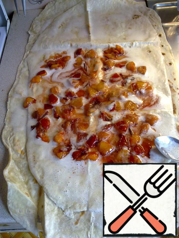 Remove from the stove our plum filling and distribute it over the entire surface of pita bread.