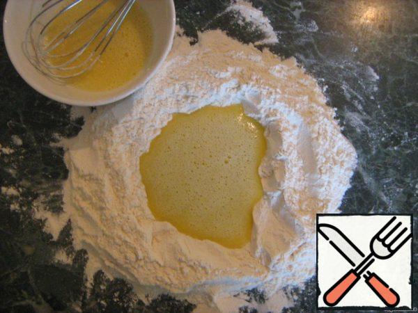 Mix flour with a pinch of salt and sugar, sift. Make a hole in it. In a separate bowl, mix one egg with vegetable oil and warm water. This mixture pour it into the well, and knead tight dough. Knead for a long time.