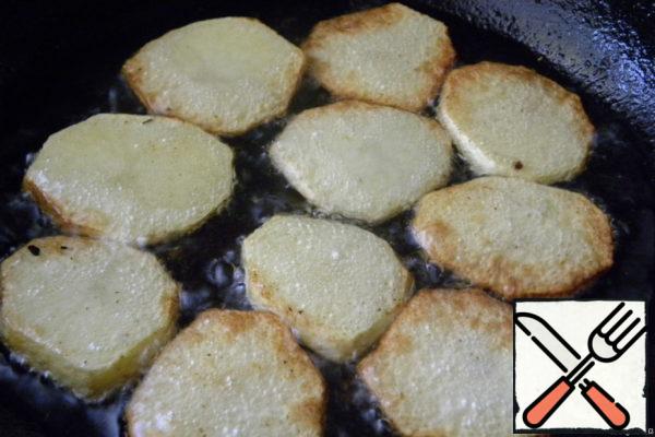 Cut the potatoes into slices and fry on both sides in oil.
