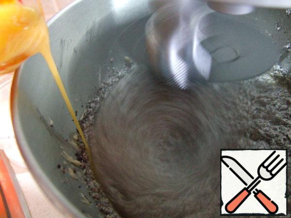Egg yolks mix with a fork and a thin stream pour into the poppy mixture.