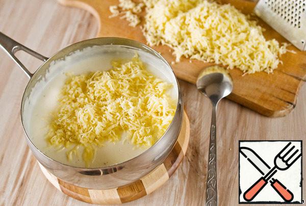 For the sauce, fry the flour in butter, pour in the milk and cream and cook for about 7 minutes until thickened. Season with salt, pepper and sprinkle with half of the grated cheese.
