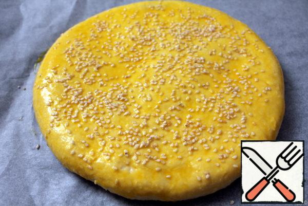 Grease the cake with yolk, sprinkle with sesame seeds and bake for 20-30 minutes.