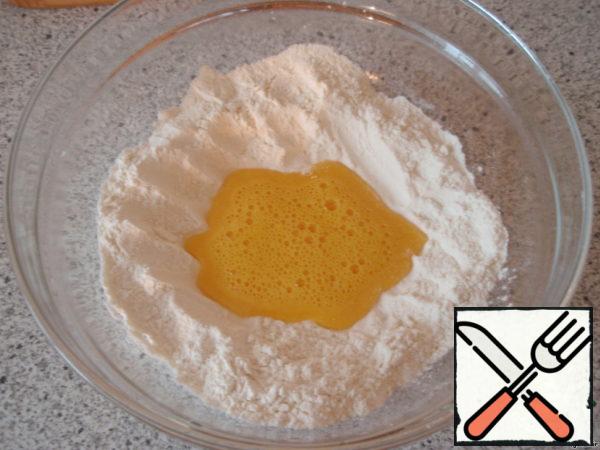 Sift the flour into a bowl and make a groove in the center. Pour the egg whipped with vinegar into it.
