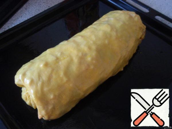 Carefully lifting the towel, roll the dough up and put on a baking sheet seam down. Grease with beaten egg and bake for 35 minutes until Golden yellow, periodically watering with milk.