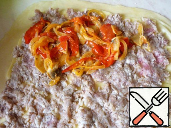 Roll out the dough thinly on a floured Board, giving it a rectangular shape.
Thinly slice the cheese, lay the slices on the dough.
Spread the minced meat evenly over the cheese and fried vegetables over it.