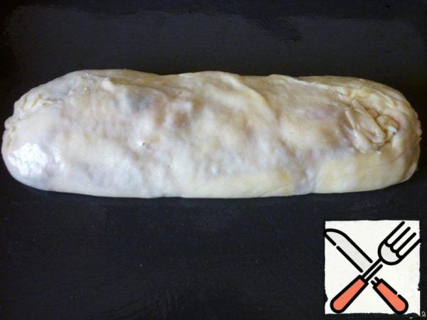 Roll out the strudel. It would be good to take over.
Place on a greased baking sheet, sprinkle with the remaining vegetable oil.
Bake for 40 minutes in a preheated 200 degree oven.
5 minutes before readiness, lubricate the strudel with a mixture of yolk and milk.